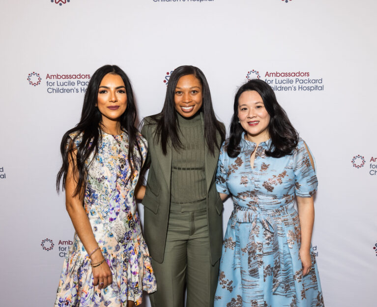 Two ambassadors pose with Allyson Felix at an event