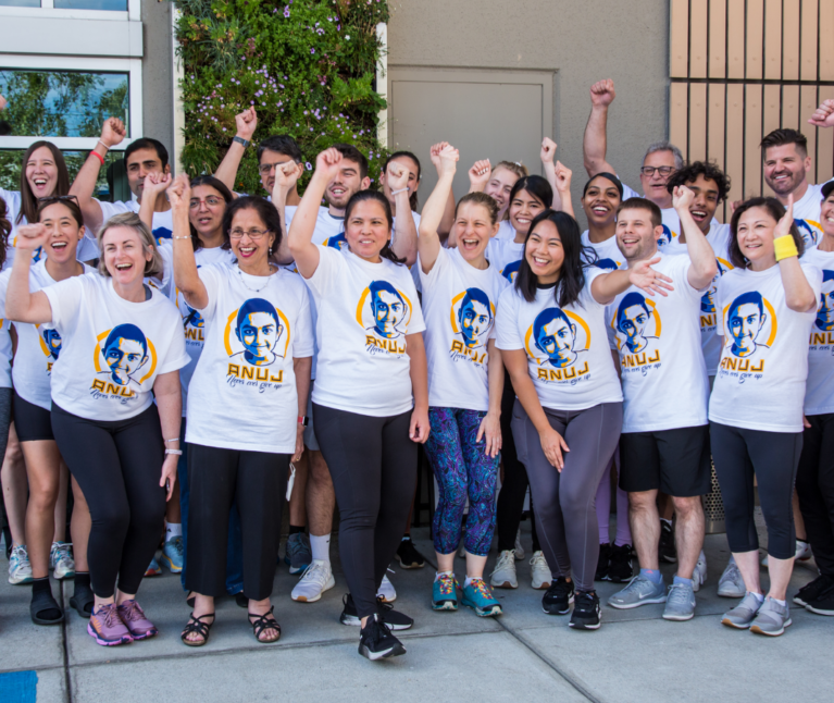 Group of people smiling with hands in the air