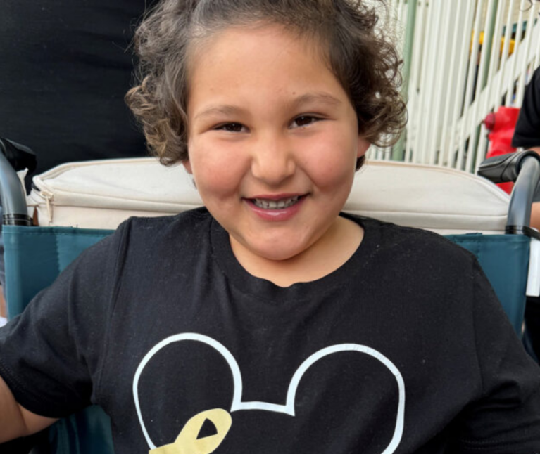 Packard Children's pediatric cancer patient in a Disney t-shirt smiling at the camera.