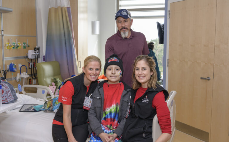 A patient and father with two hospital staff in a hospital room