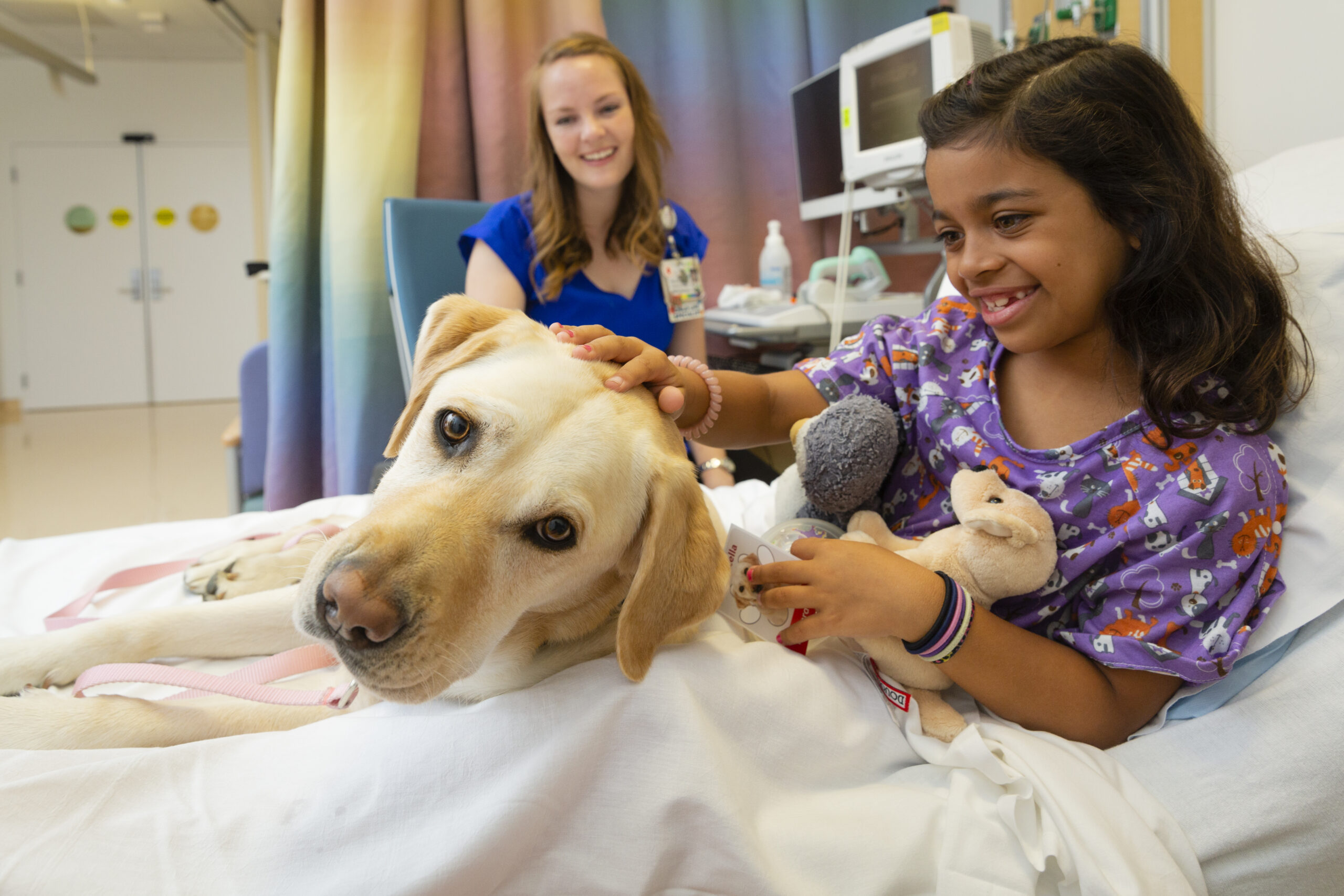 Young patient petting a therapy dog