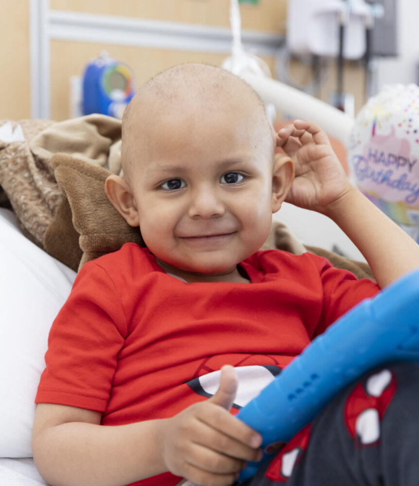 Young cancer patient smiles in bed