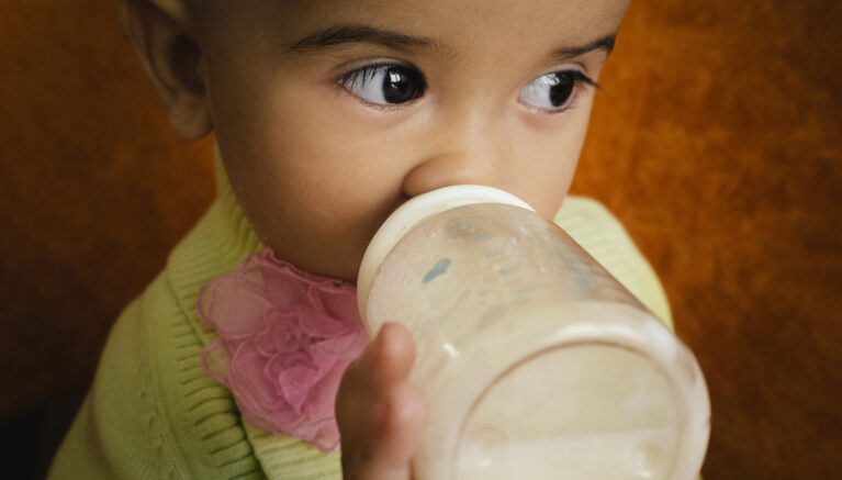 Closeup of a child drinking from a bottle