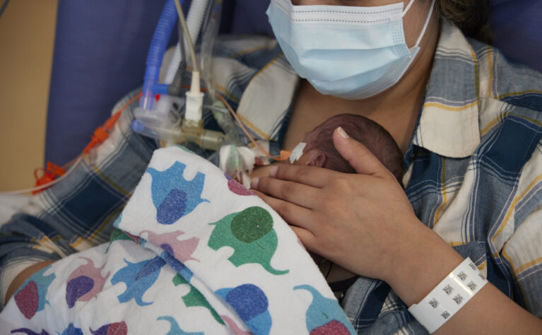 Mother in NICU lovingly holding her child to her chest