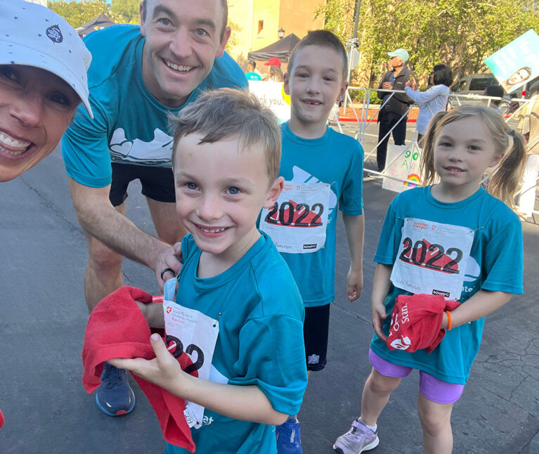 Siblings Matthew, Kate, and Alex posing with their parents at Summer Scamper.