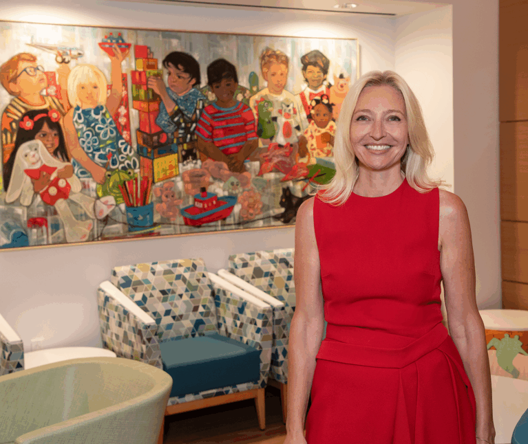 Dr Tanja Gruber stands in front of a painting in the waiting room of the new Bass Center Clinic and Infusion Center