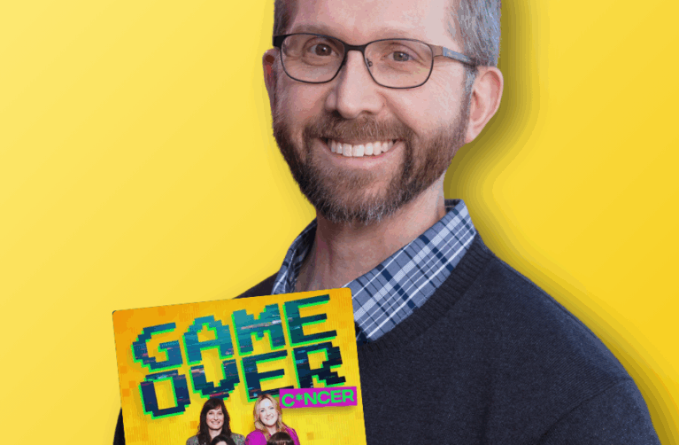 Adult pediatric cancer survivor smiling at the camera in front of a yellow backdrop. A logo of the Game Over Cancer podcast on the left-hand side.
