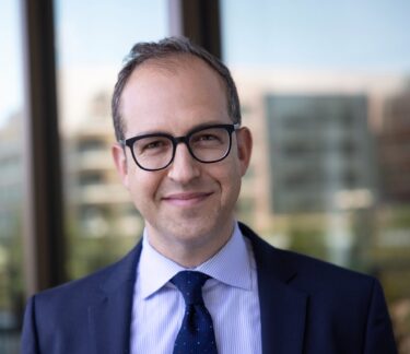 Doctor Yair Blumenfeld stands in front of a window.