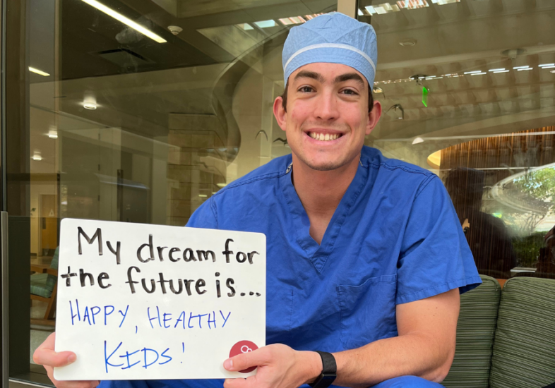 Hospital staff holding a white board that reads "My dream for the future is Happy, Healthy Kids."
