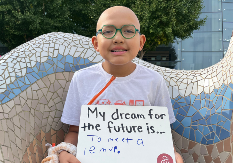 Patient holding a white board that reads "My dream for the future is to meet a lemur."