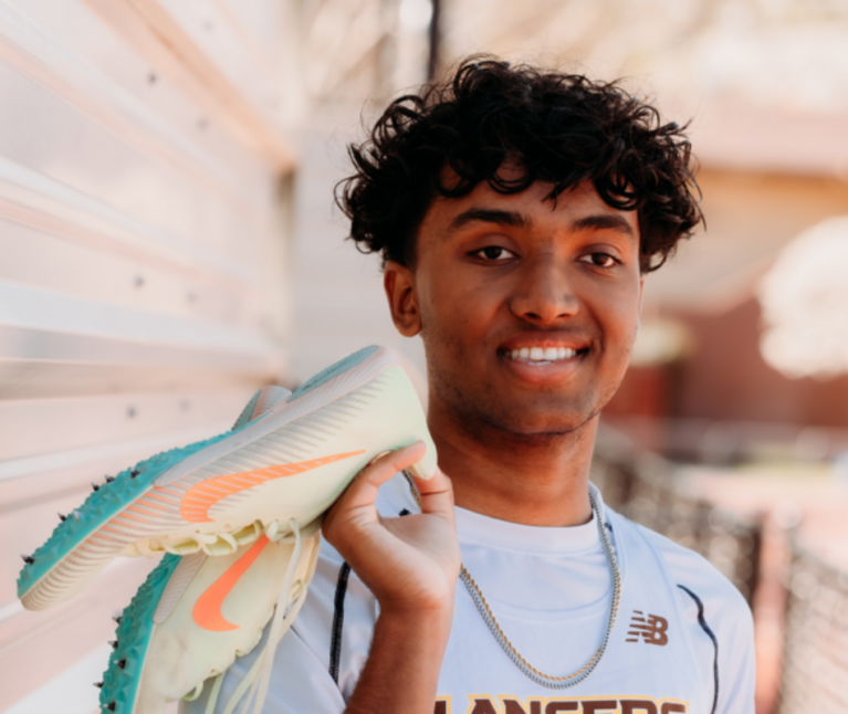 Former neurology Packard Children's patient in their high school sports uniform smiling at the camera.