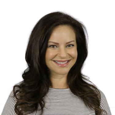 A person with long dark brown hair smiles at the camera against a white background. They wear a black-and-white striped top.