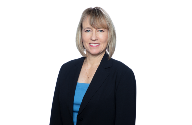 Stanford reproductive health physician posing for a picture and smiling at the camera. They wear professional attire including a blue top and black blazer.