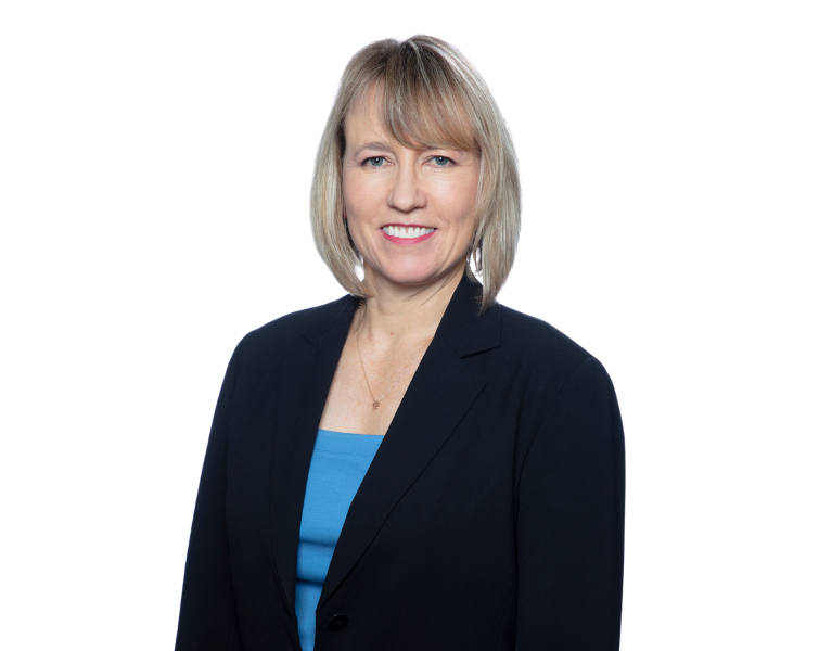 Stanford reproductive health physician posing for a picture and smiling at the camera. They wear professional attire including a blue top and black blazer.