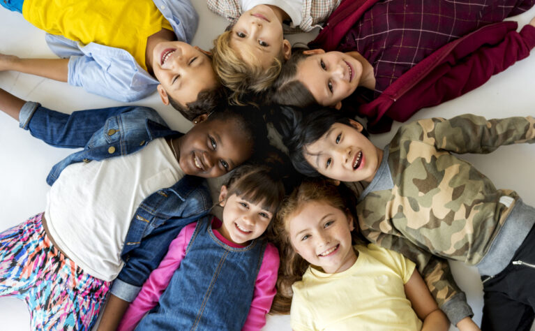 A group of children lying on the ground and smiling