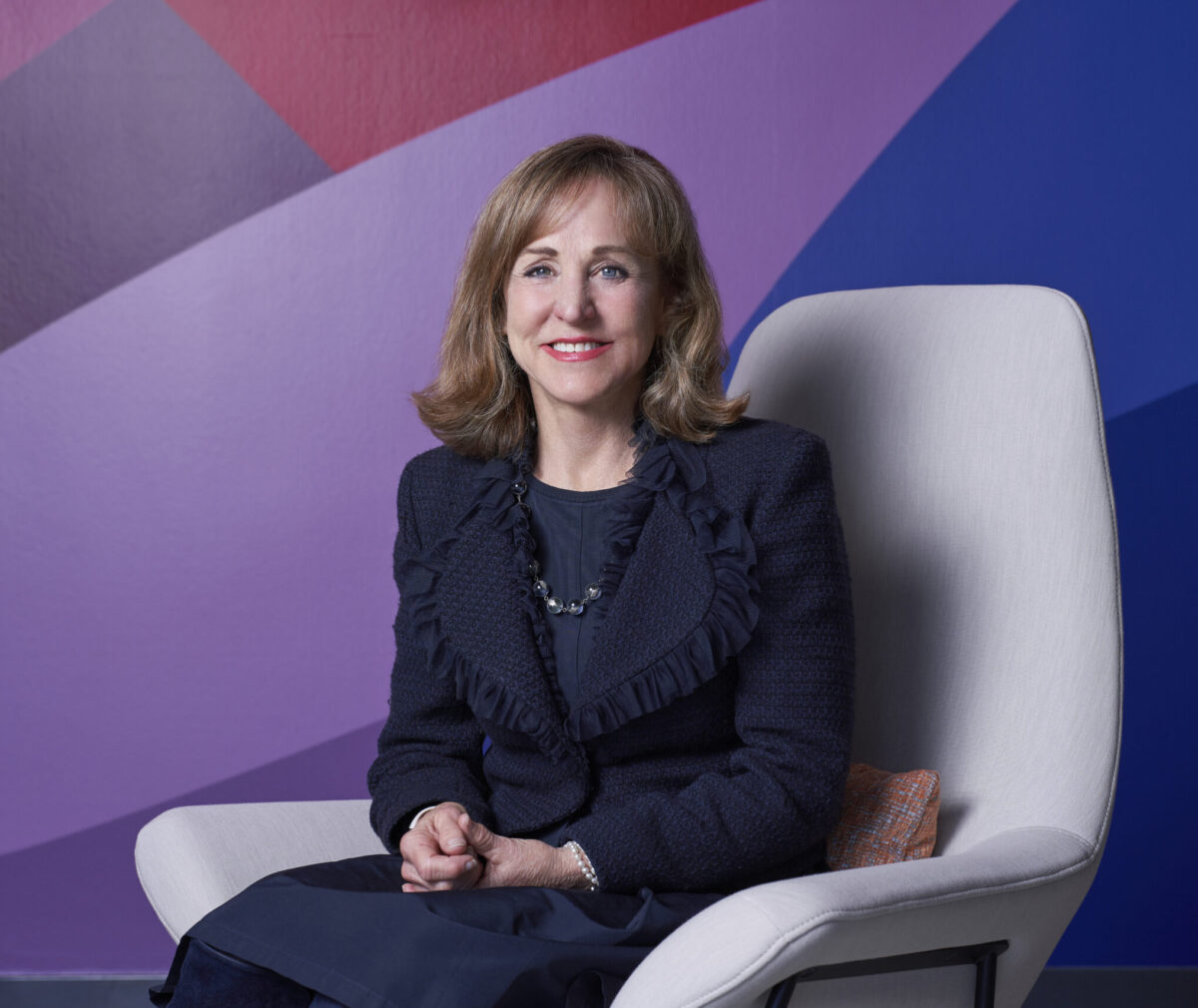 Susan Ford Dorsey sitting, smiling at camera.