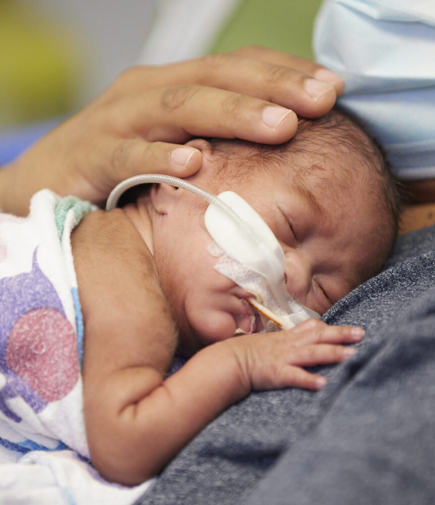 Newborn patient sleeps on father's chest