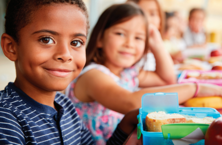 Children sitting at lunch table.