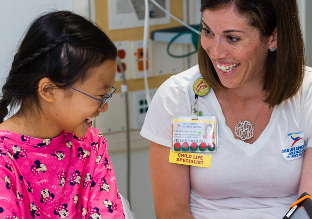 Child life specialist smiling with a young patient