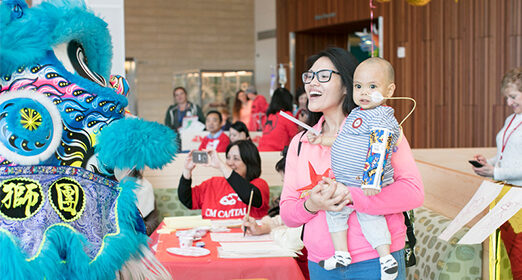 Adult hold child at Lunar New Year event.