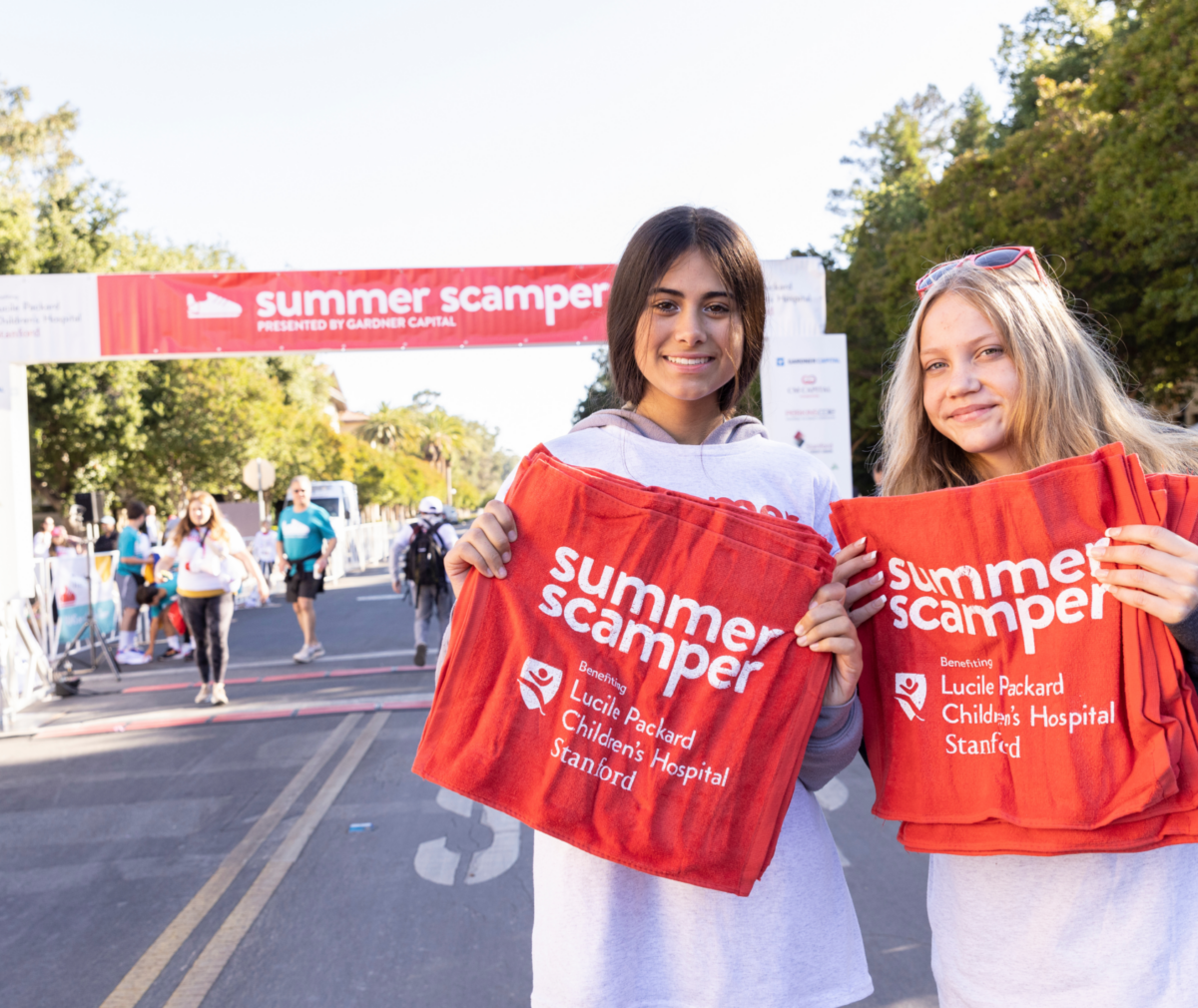 Two volunteers of Summer Scamper holding towels for participants.