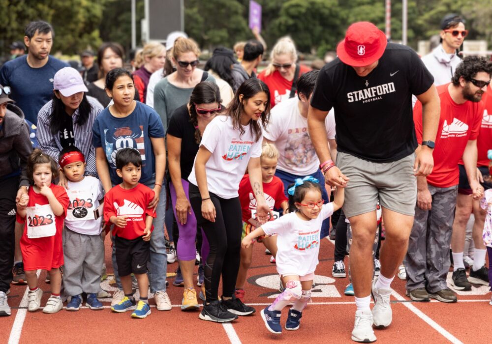 Parents and young children running on a track.