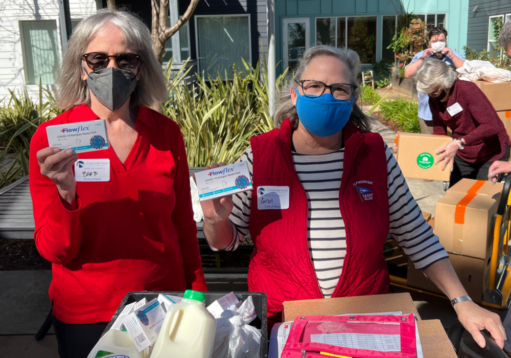 Volunteers at the Office of Child Health Equity holding donated covid-19 kits.