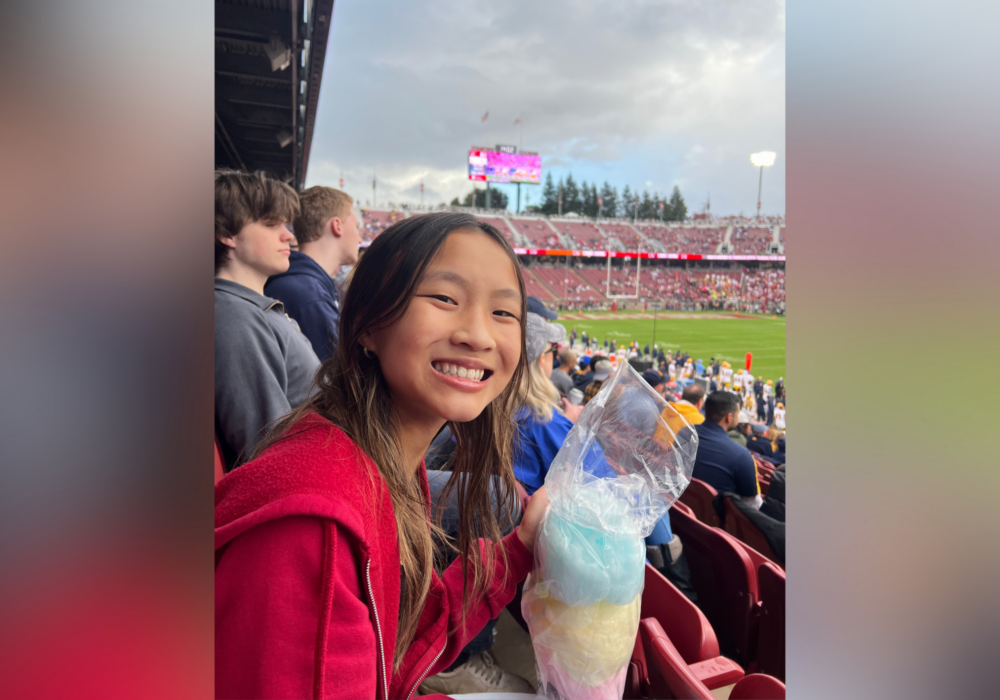Jocelyn at baseball game eating cotton candy.