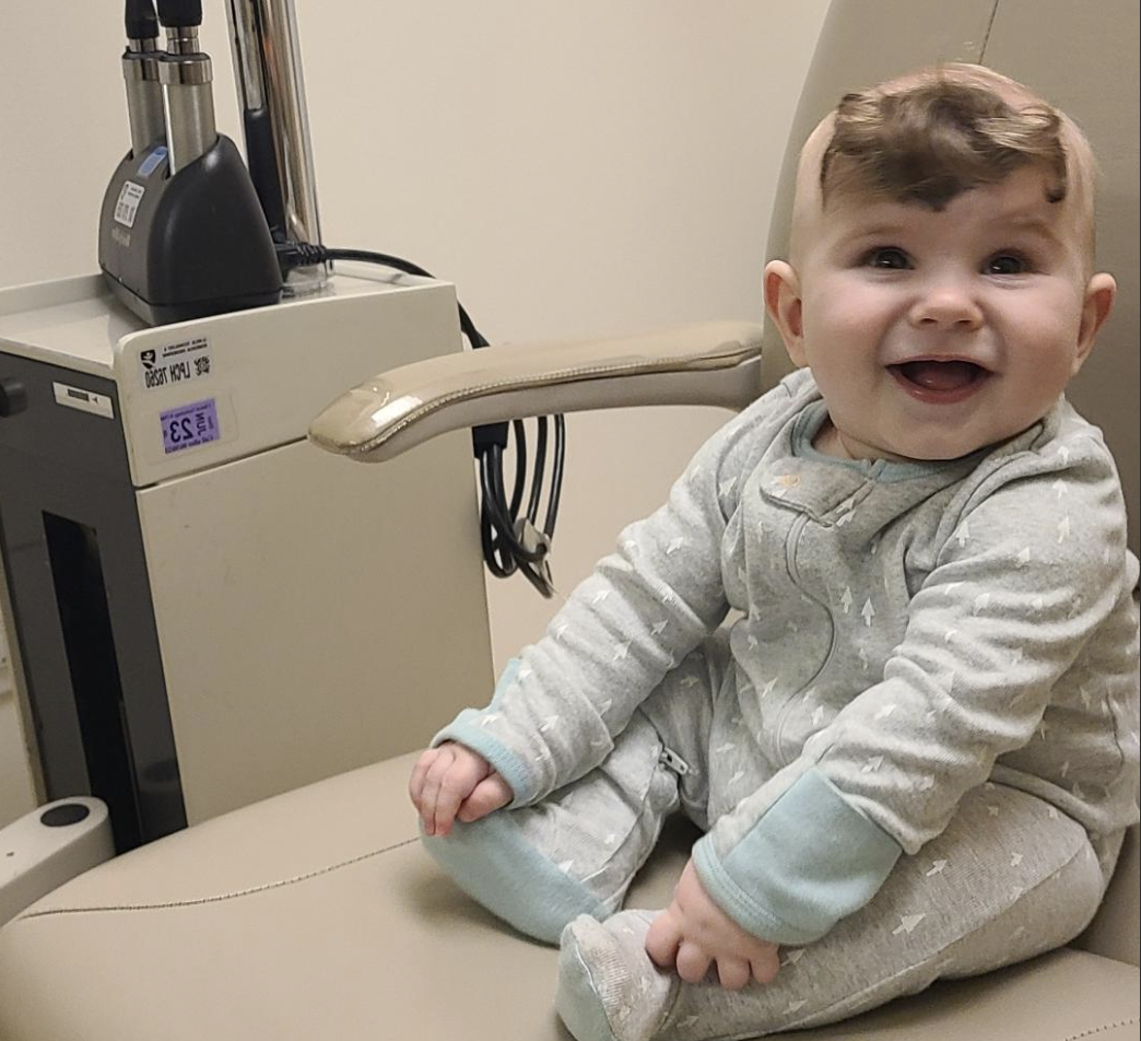 Weston sitting and smiling in medical chair.