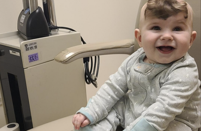 Weston sitting and smiling in medical chair.