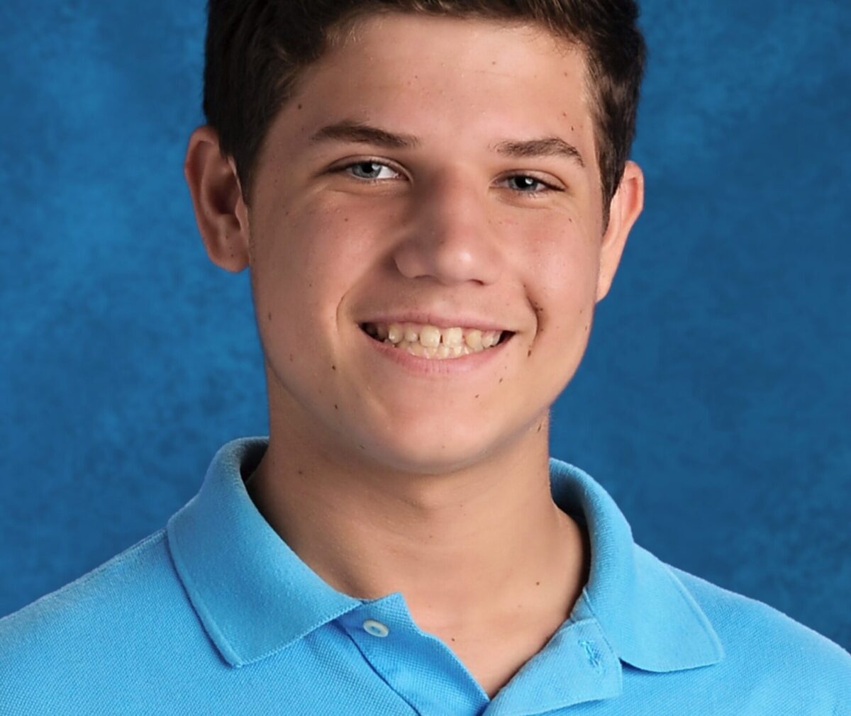 Teen pediatric patient smiling at camera.