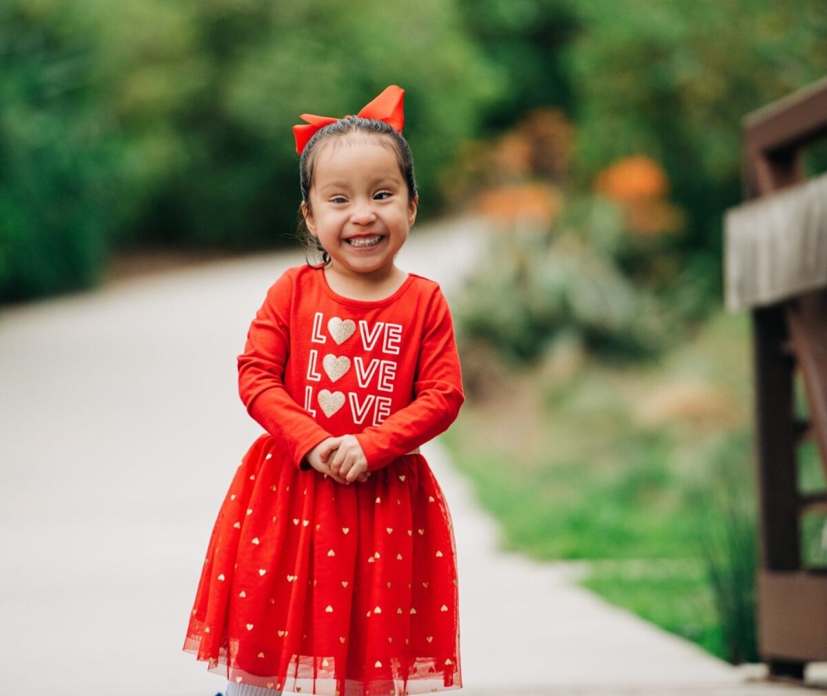 Iliana in red dress smiling at camera.