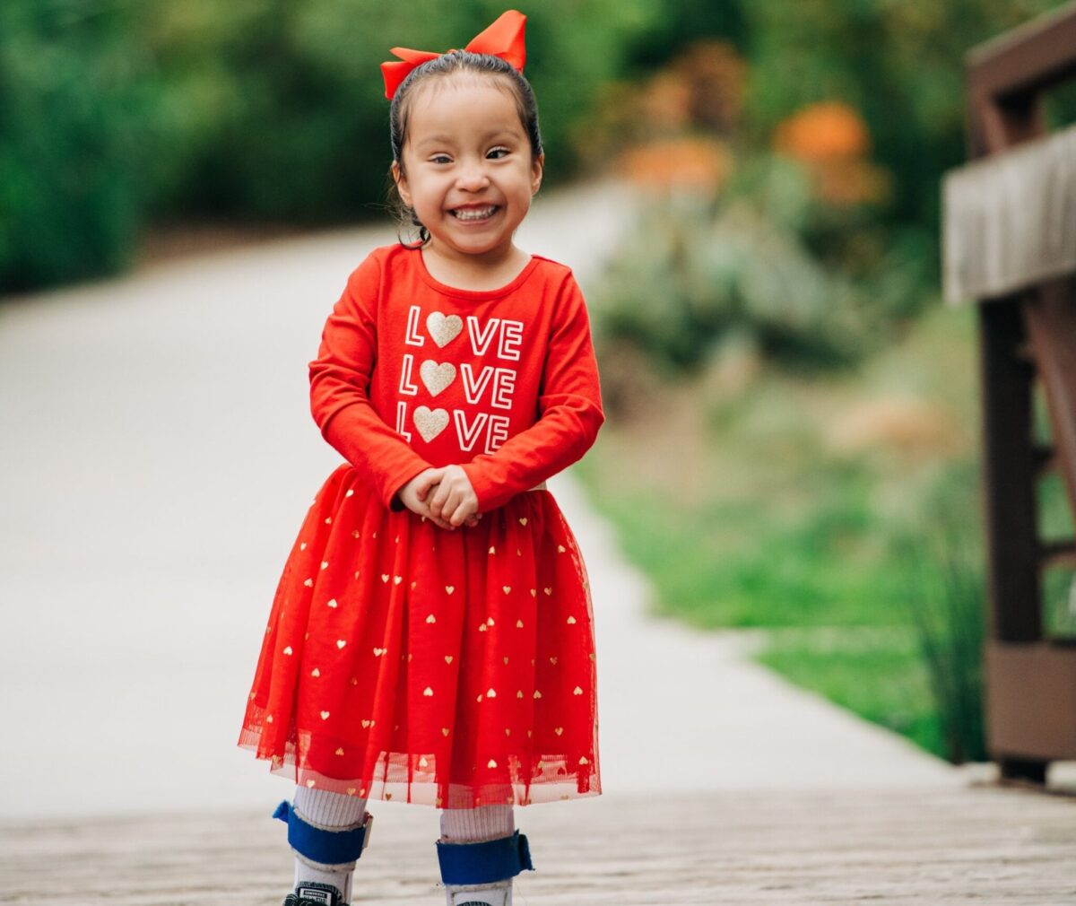 Iliana in red dress smiling at camera.
