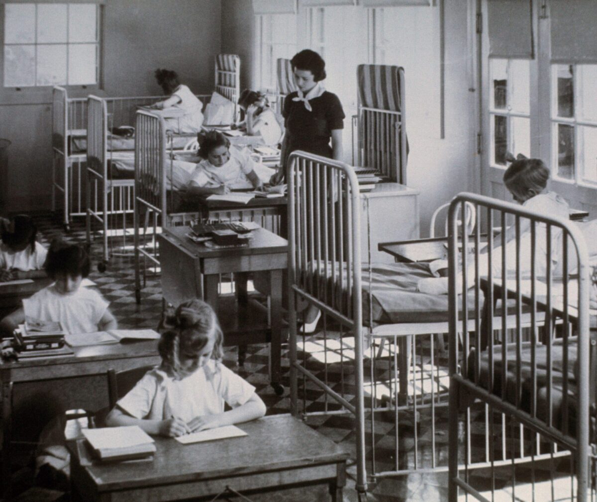 Older photo of Stanford Home for Convalescent Children. Children sitting and working at their desks.