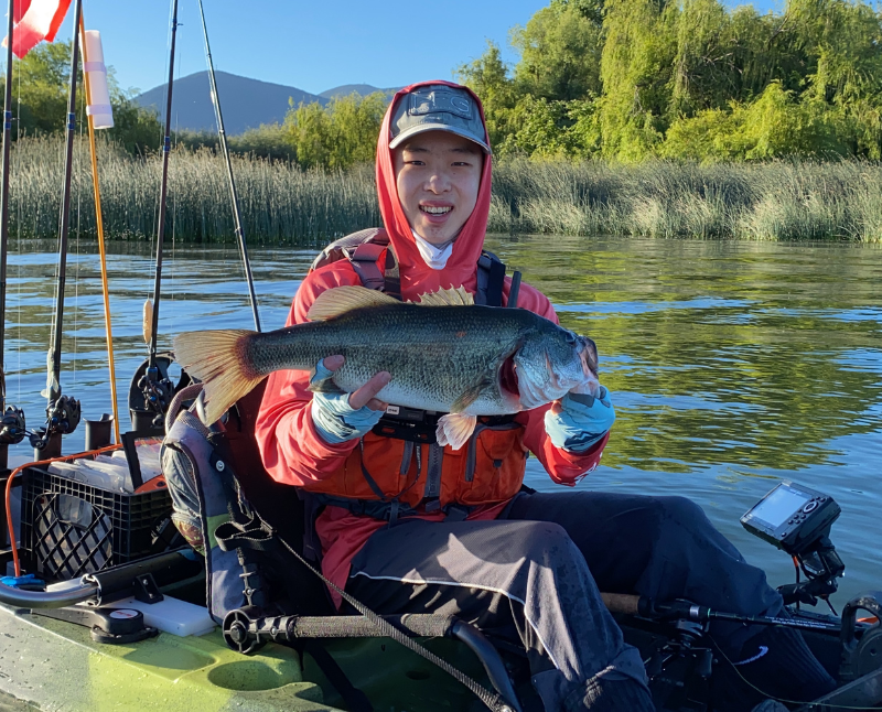Young adult male holding a freshly caught fish.
