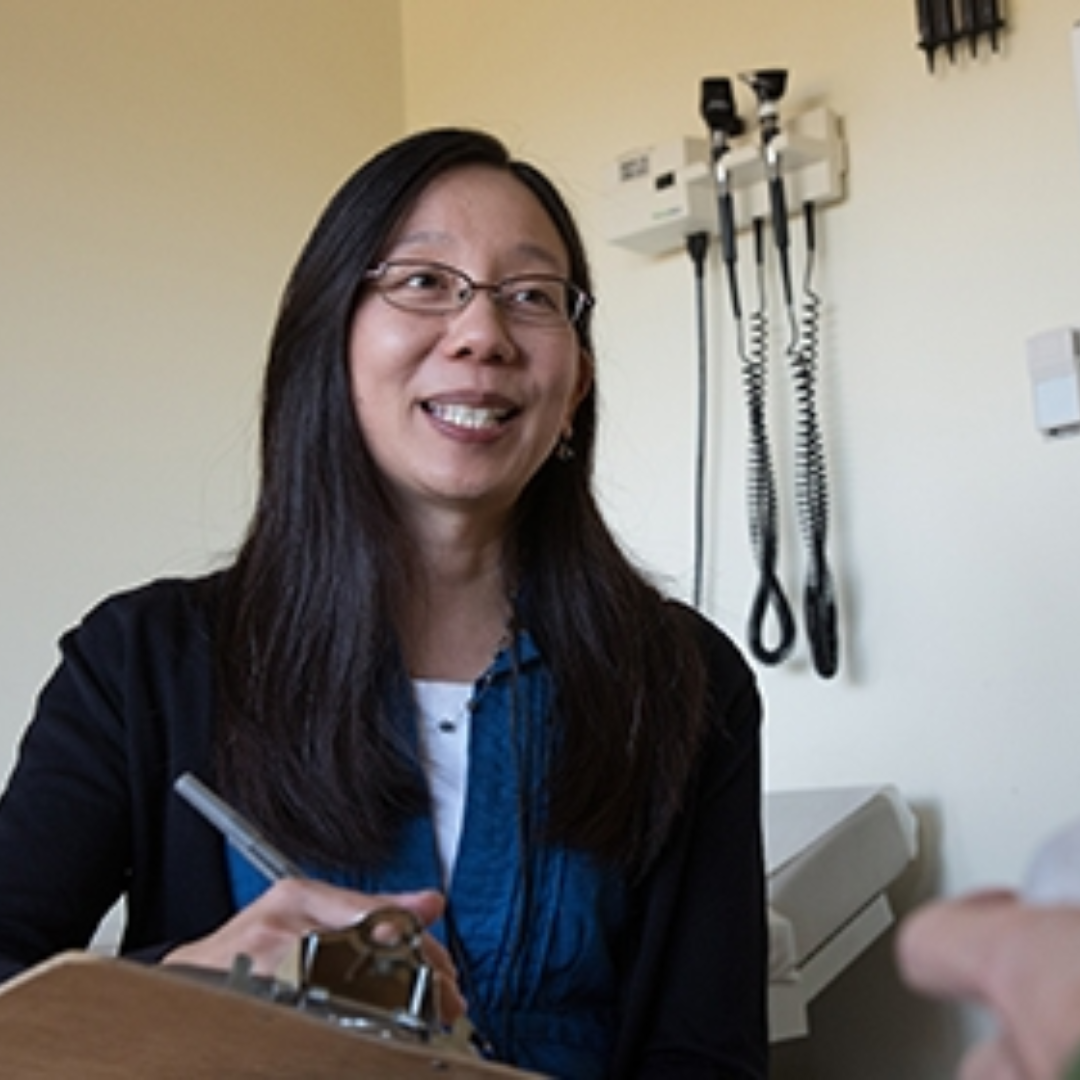 Doctor taking notes while speaking to a patient
