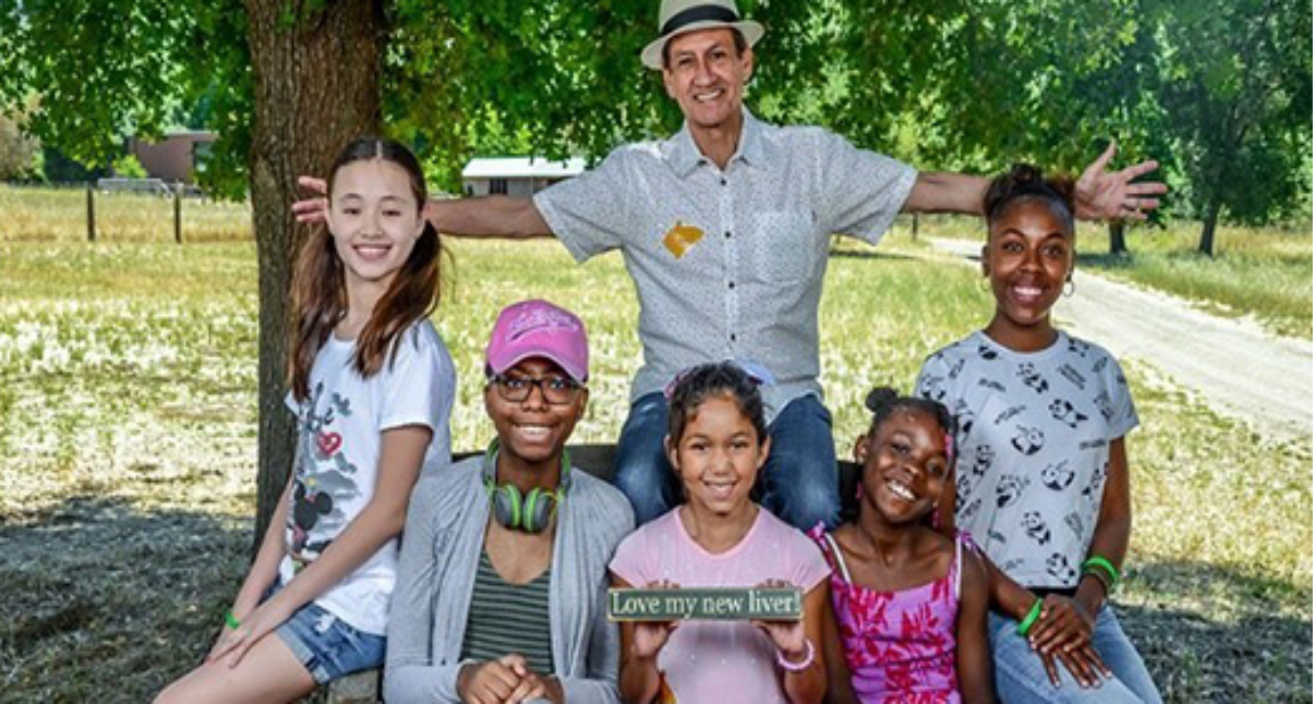 Man with children at a park, smiling