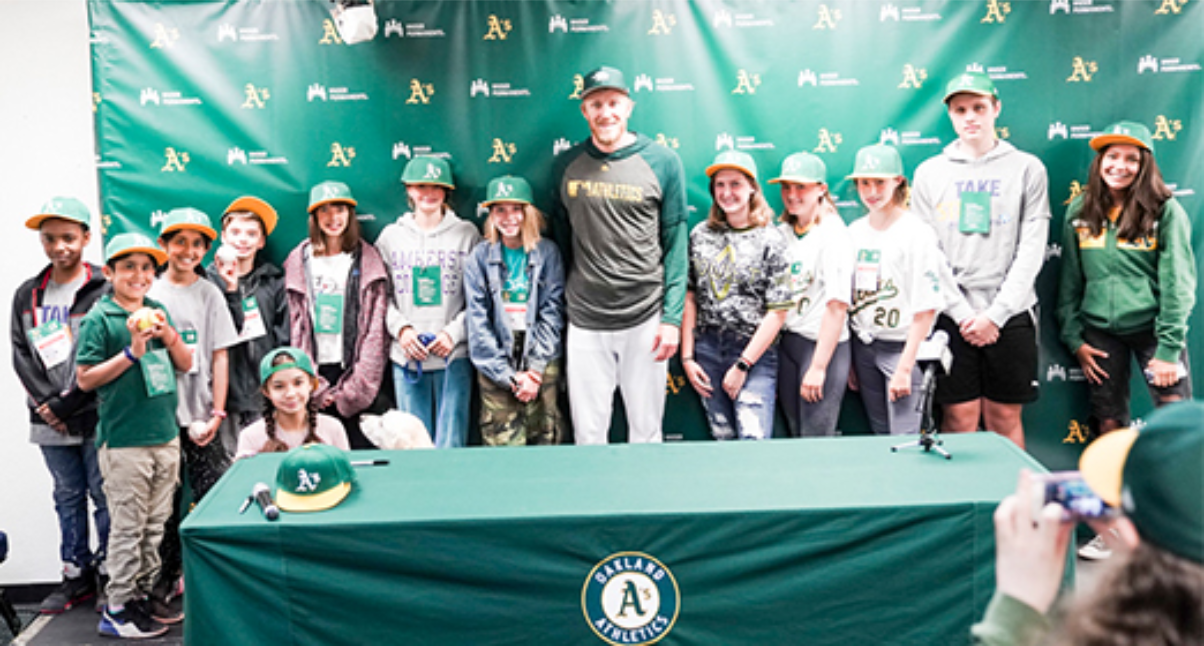 Baseball team posing behind table, smiling