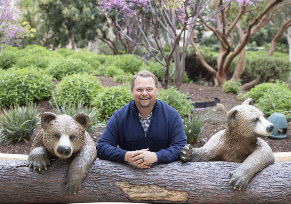 Dr. Justin Baker posed with bear sculptures.