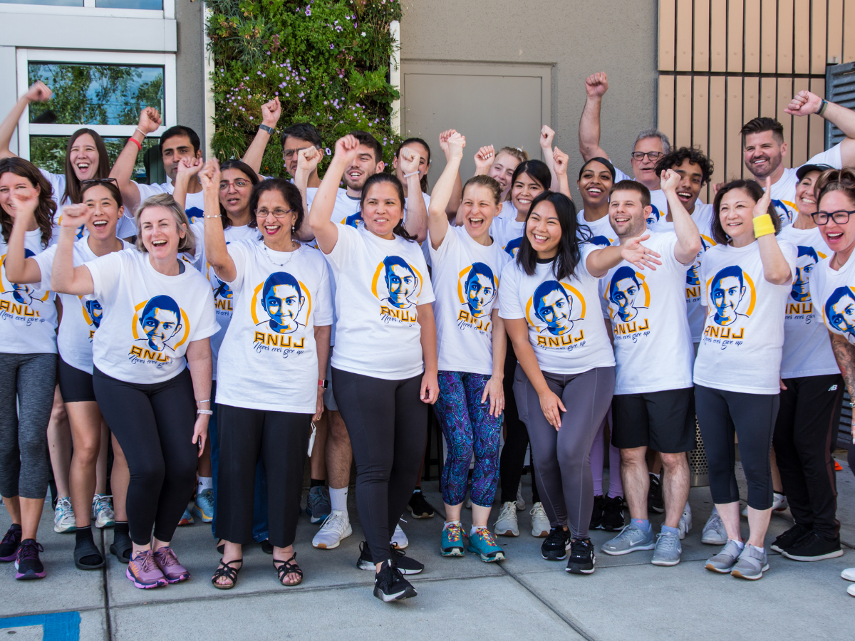 Group of people smiling with hands in the air