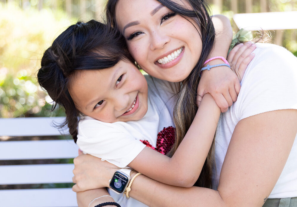 Mikayla and woman hugging and smiling.