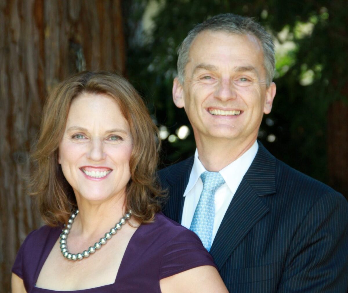 Two adults posing for a picture and smiling at the camera.