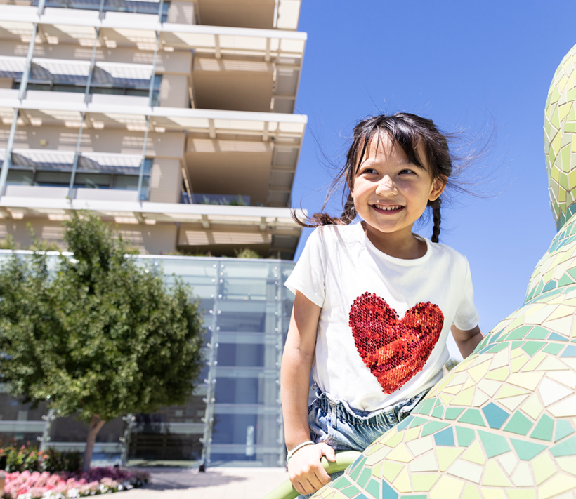 A young heart patient wearing a heart shirt climbs a piece of play equipment at the Lucile Packard Children's Hospital.