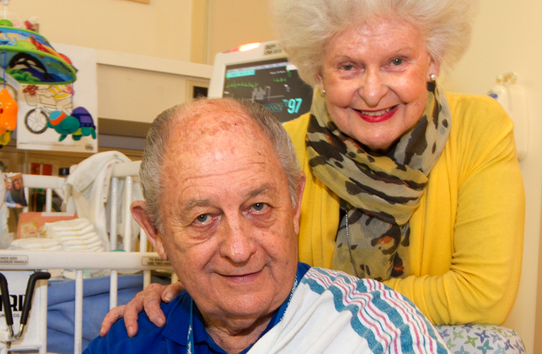 Married couple Pat Rice and Claire Fitzgerald holding a newborn baby in a hospital room at Stanford Children's Hospital.