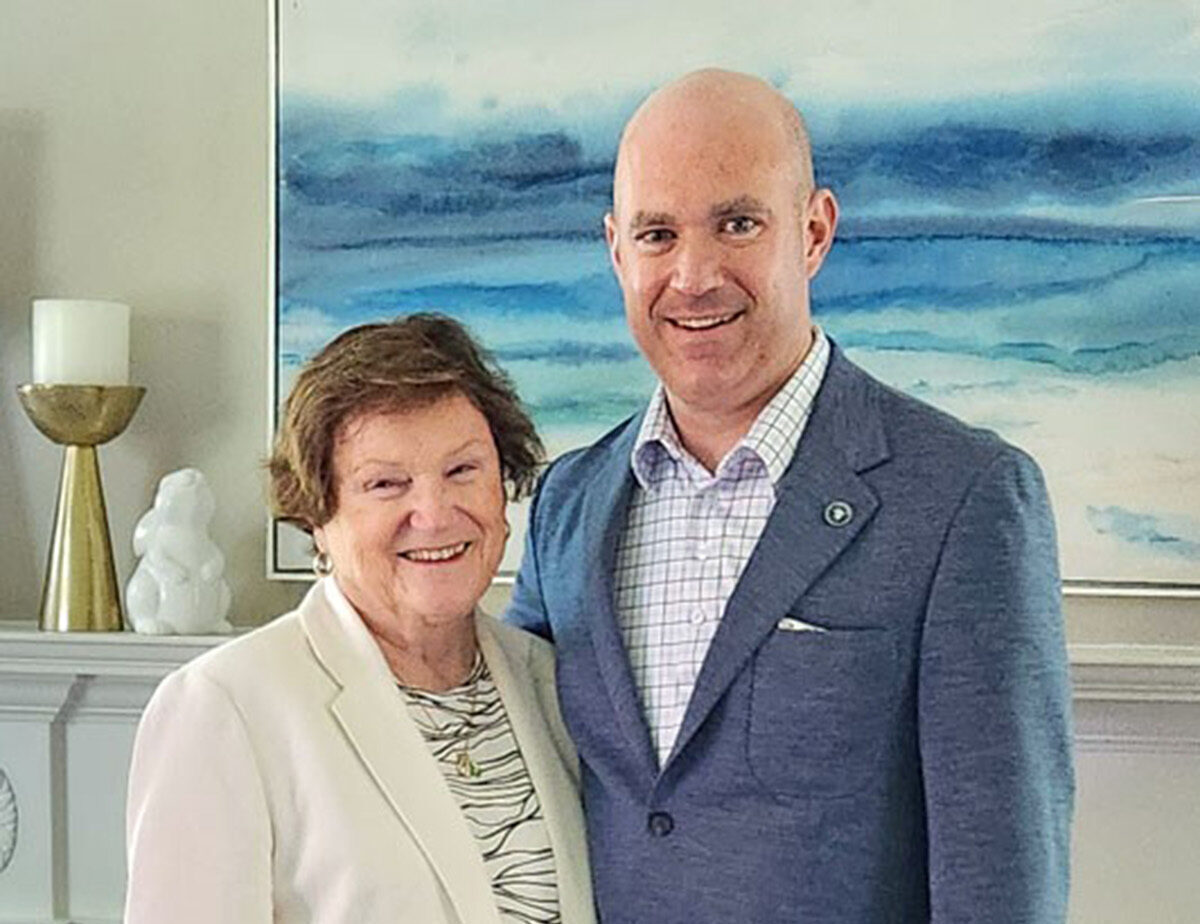 Elaine standing with her now grown, adult son.