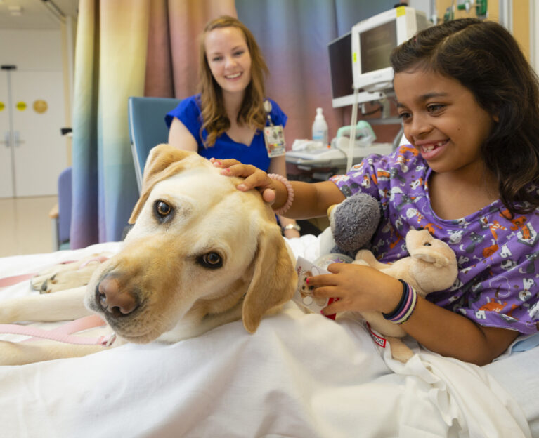 Young patient petting a therapy dog