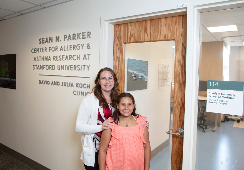 Entrance to the Sean N. Parker Allergy and Asthma Research Center with patient and doctor smiling in front of the door.