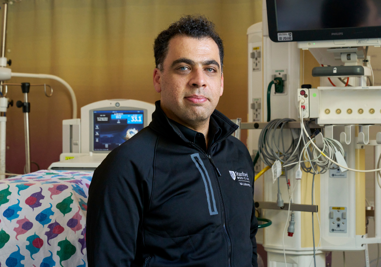 Dr. Nima Aghaeepour standing in a patient room, looking at the camera.