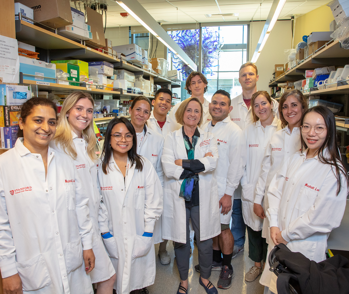 Dr Crystal Mackall poses in her lab with her team.