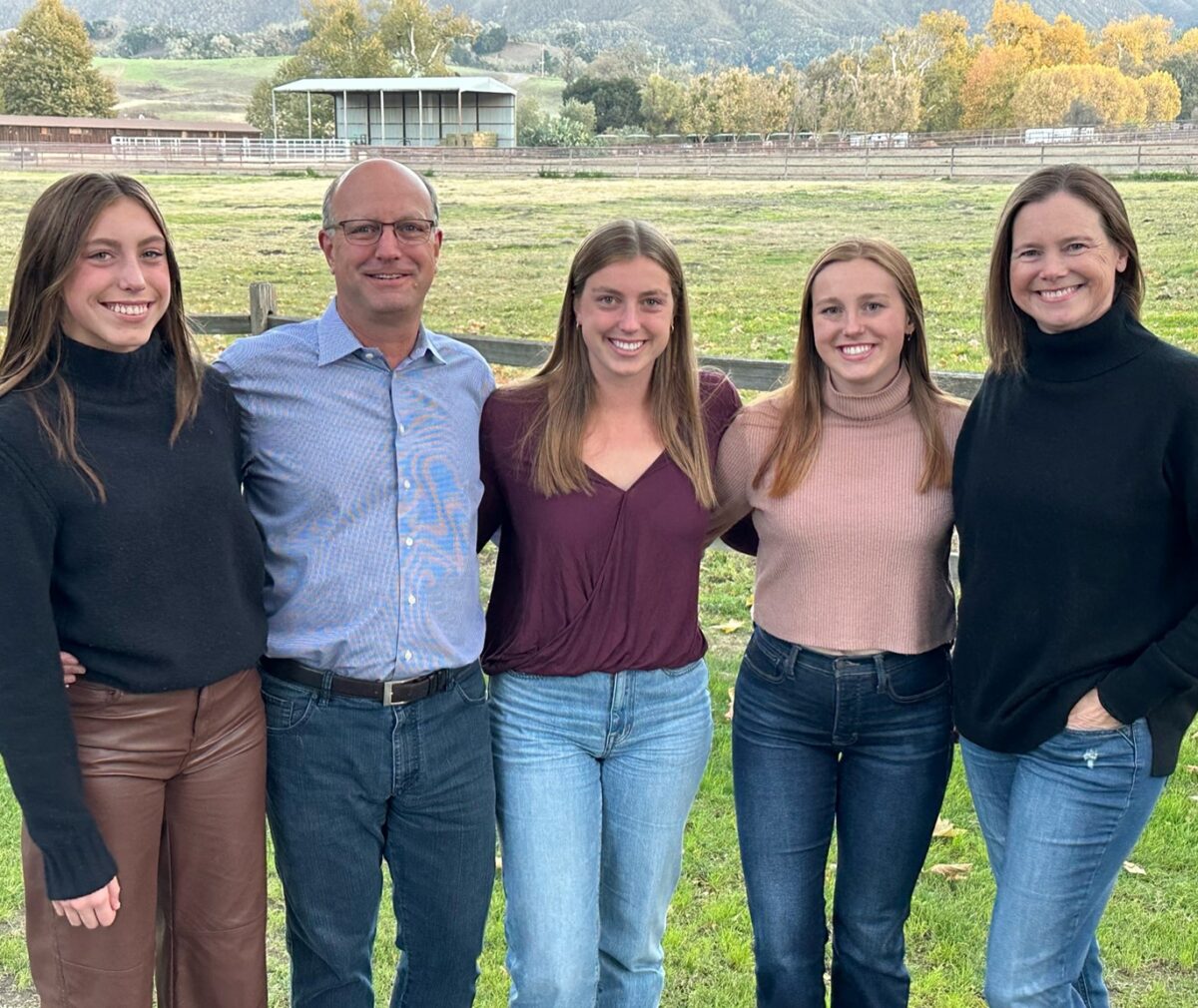 Becky Long and Ken Hirsch smile alongside their three daughters.